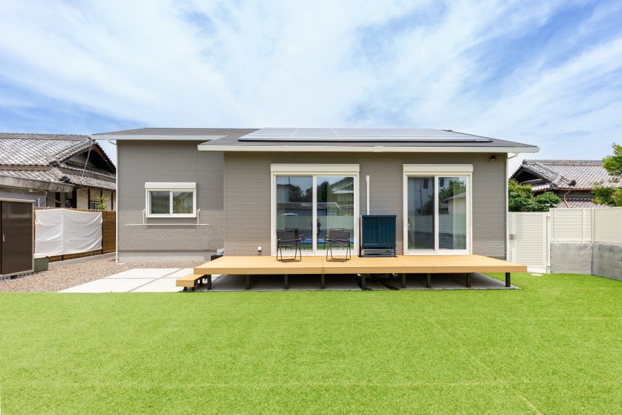 芝生のグリーンに映えるアースカラー+ホワイトの平屋