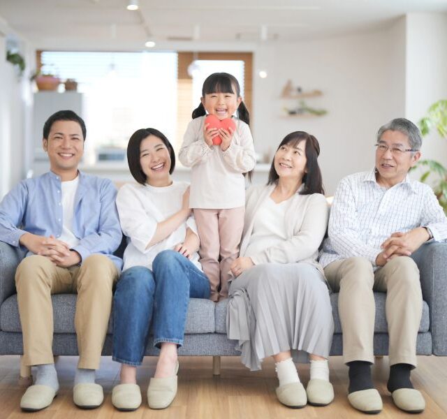 ソファの上で笑顔の3世代家族