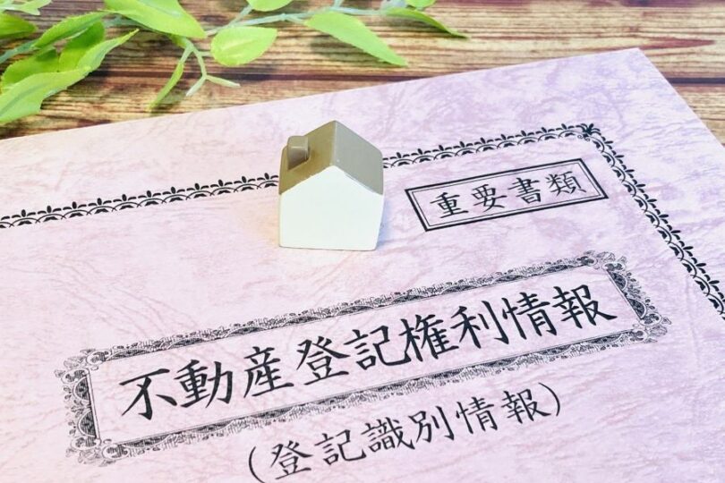 不動産権利証の上に家のオブジェ