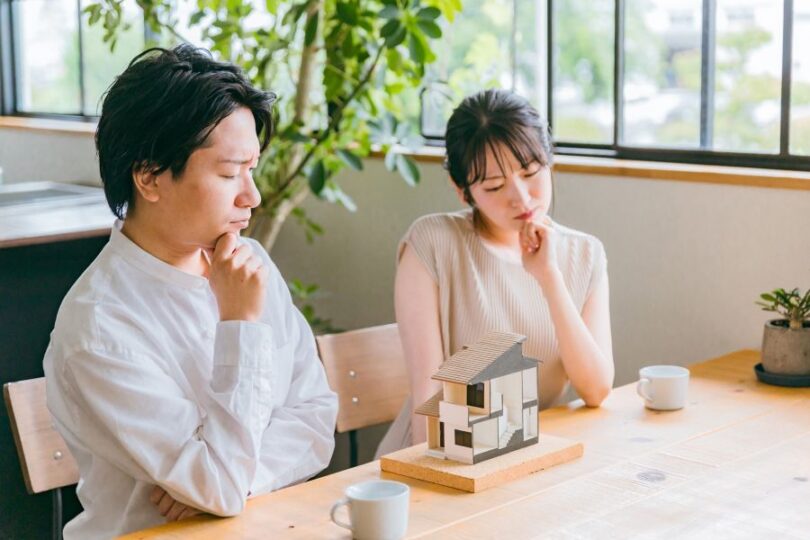 家の模型を前に悩む夫婦